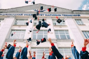 new graduates throwing their graduation hats upward