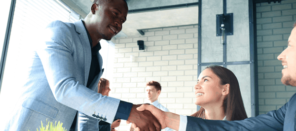 two men in formal suits shaking hands